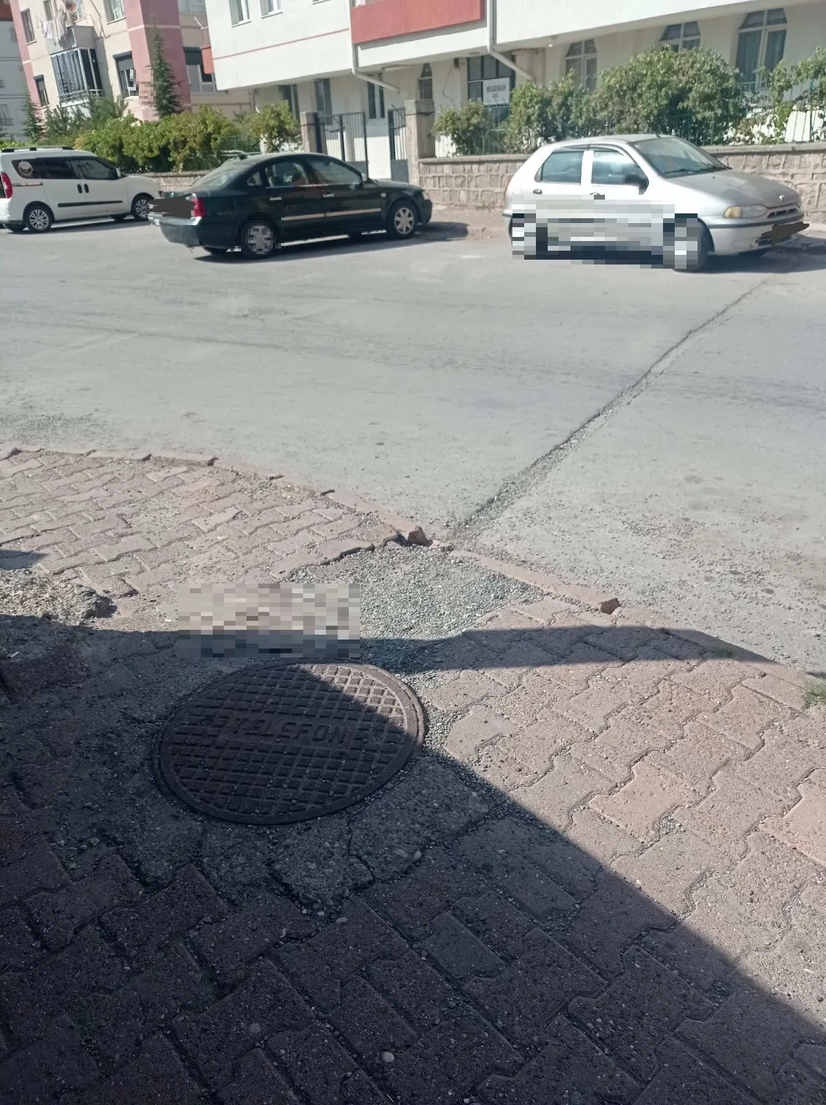 Kaldırım taşı eksik ve yolda çukur var.