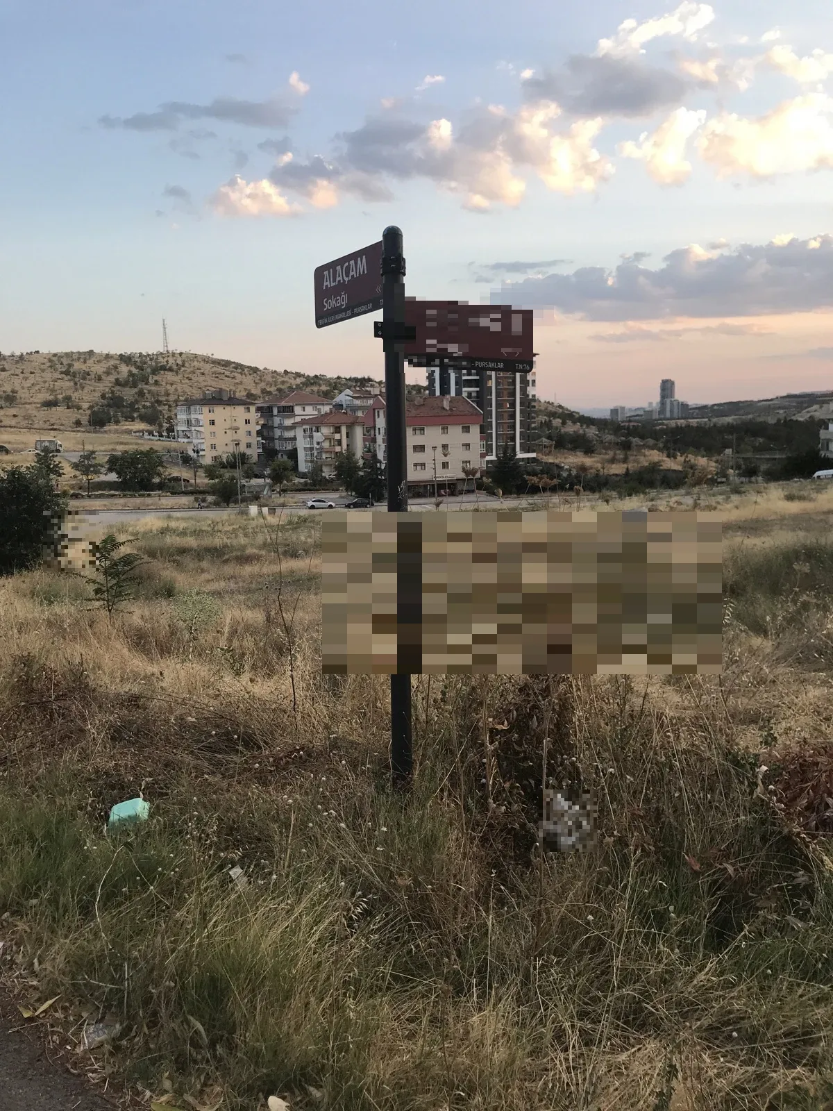 Sokak tabelası yan yamulmuş ve etrafi çalılık dolmuş .Temizlik göstermiyor